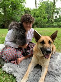 Zeus, a black and tan German Shepherd sits by his caretaker, Elvin